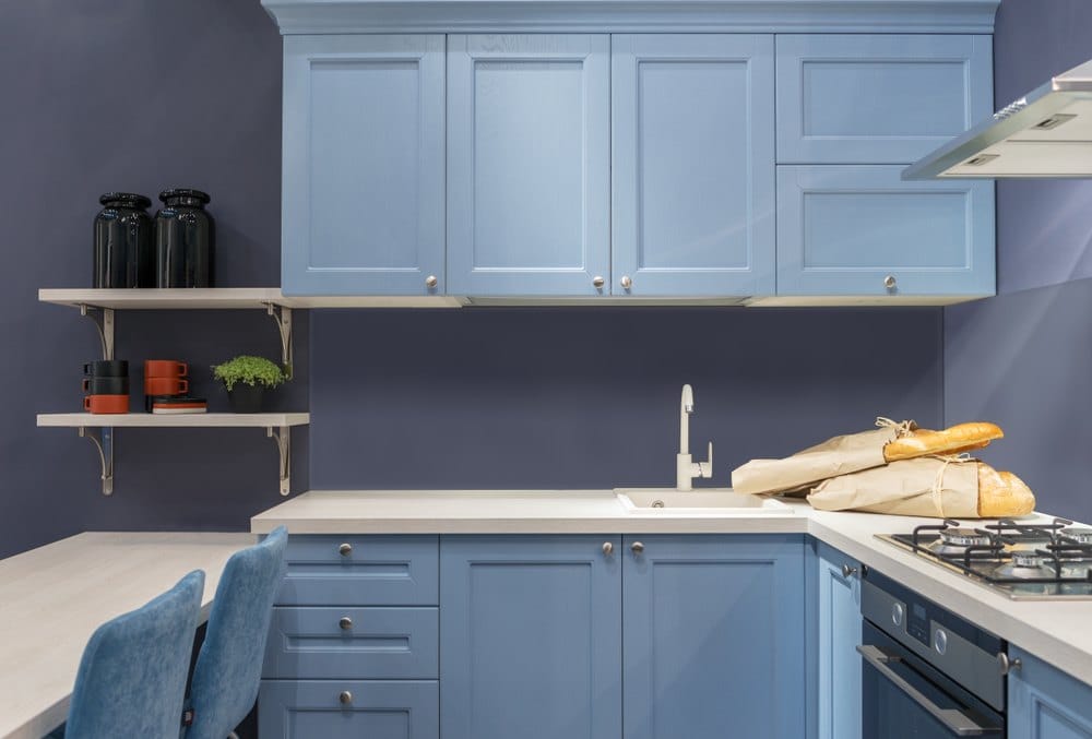 blue kitchen with dark blue backsplash wall 