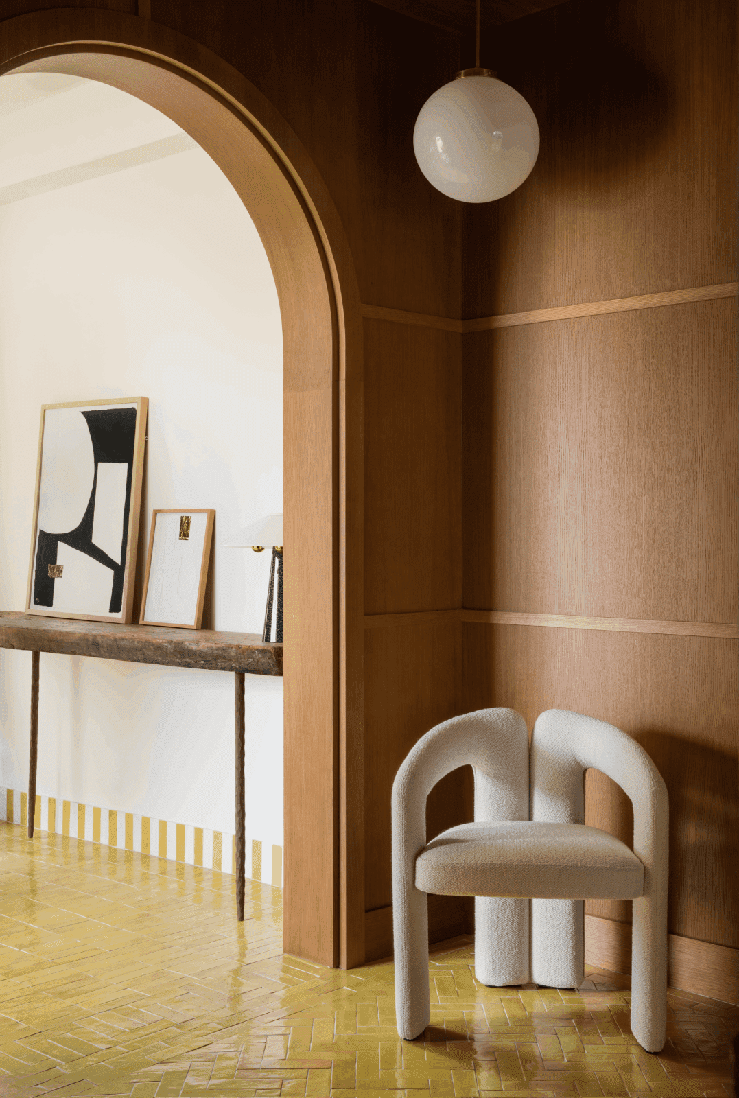 hall de entrada con suelo amarillo, paredes de madera y silla de diseño blanca
