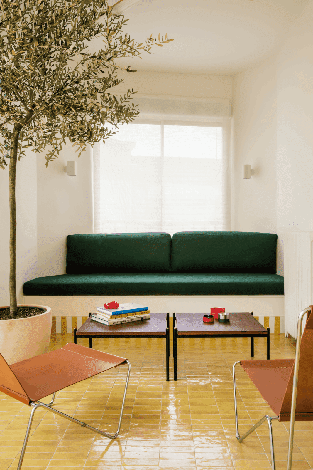 sala de estar con sofá verde en apartamento de diseño en Madrid con suelo amarillo
