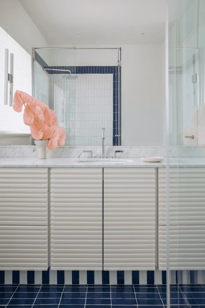 modern bathroom with white vanity and blue tiled floor