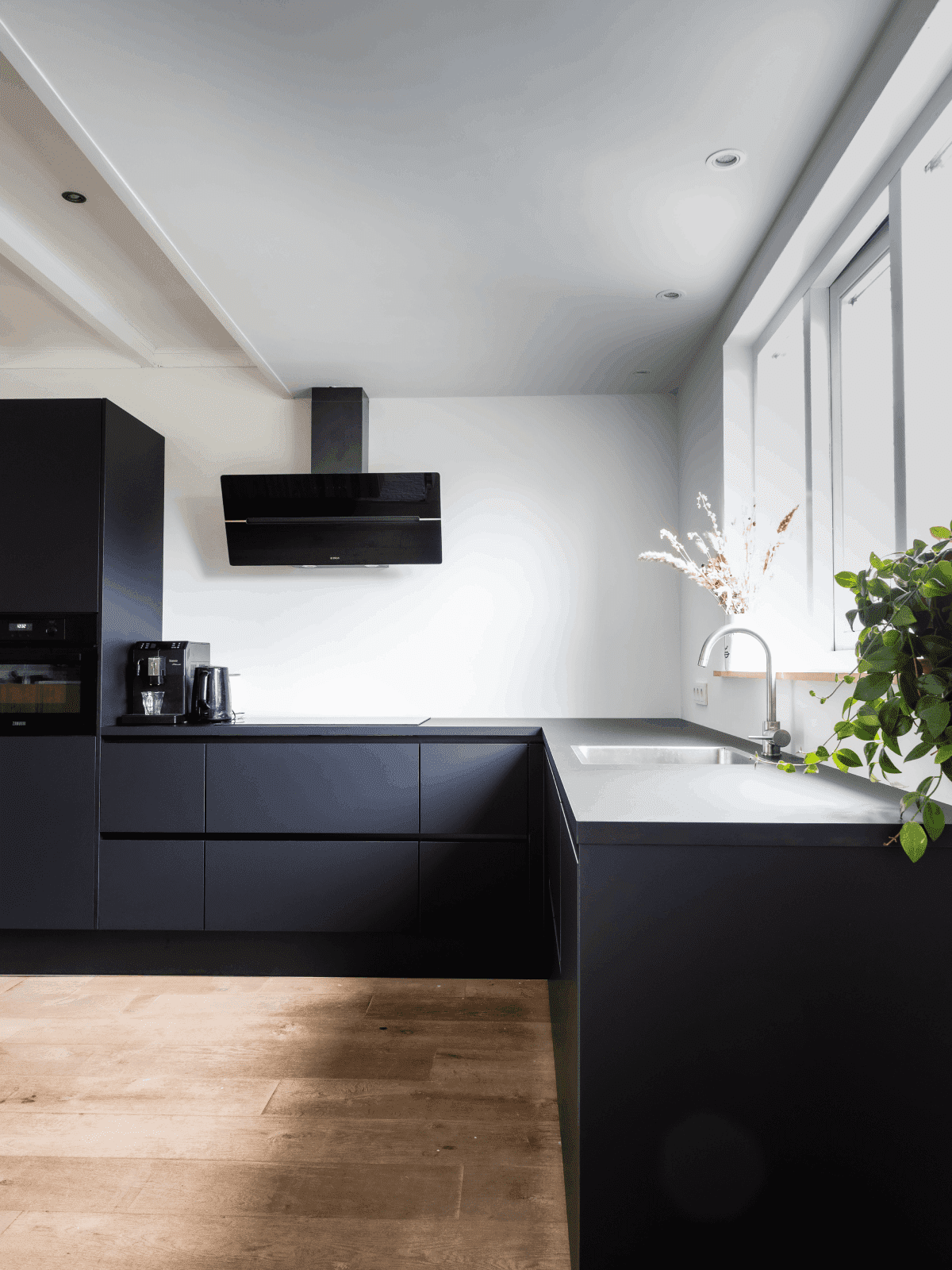 cocina integral moderna de color negro con pared blanca minimalista