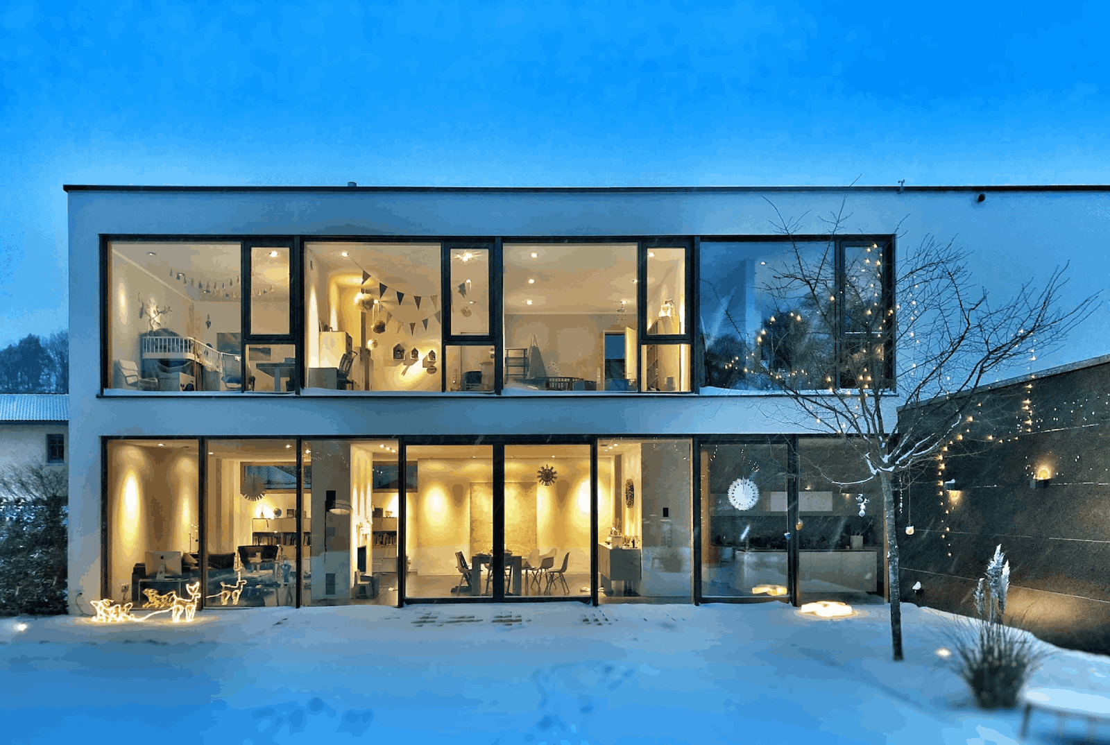 Fachada de casa de dos pisos minimalista con ventanales 