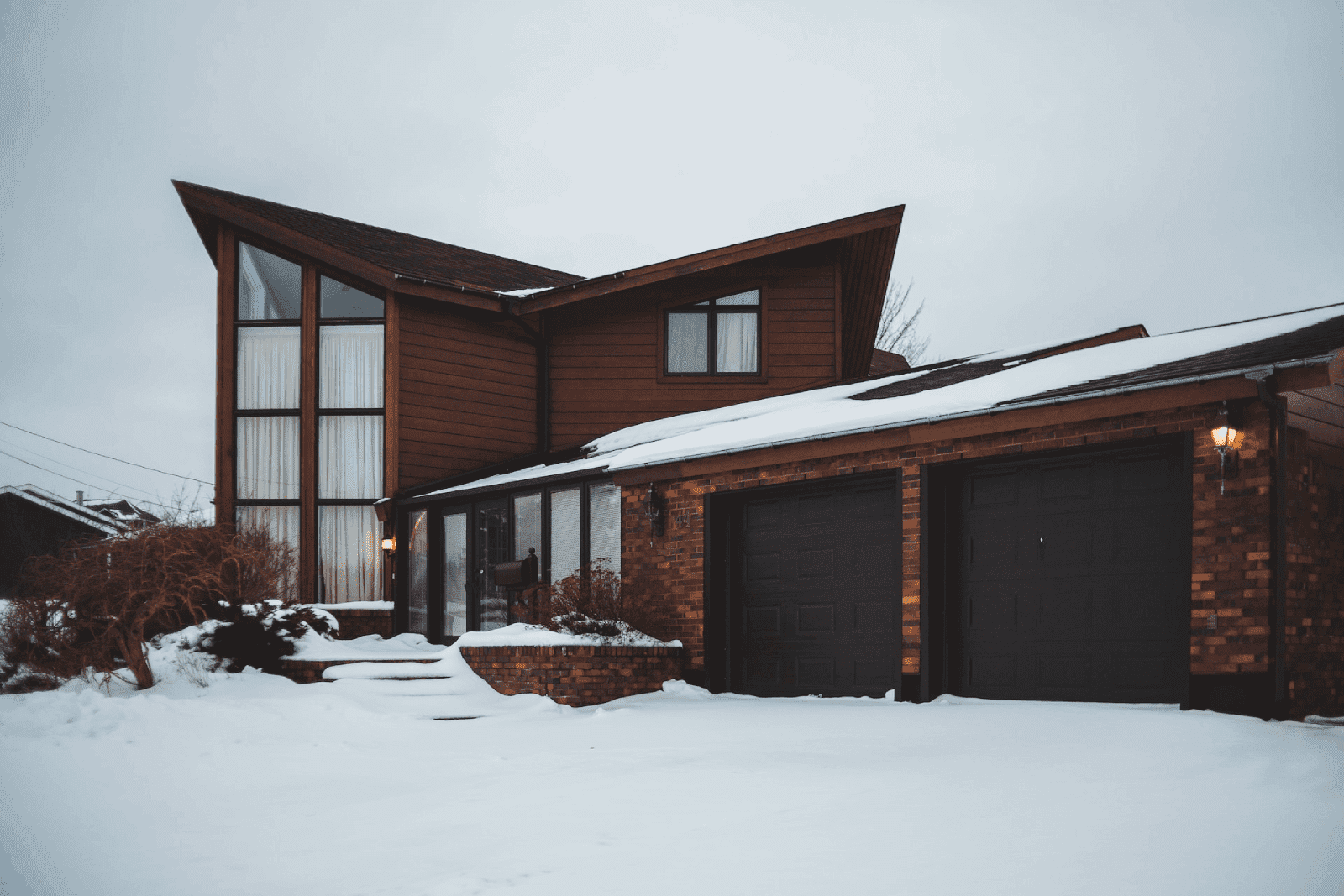 fachada de casa moderna de dos pisos con cochera en la nieve 