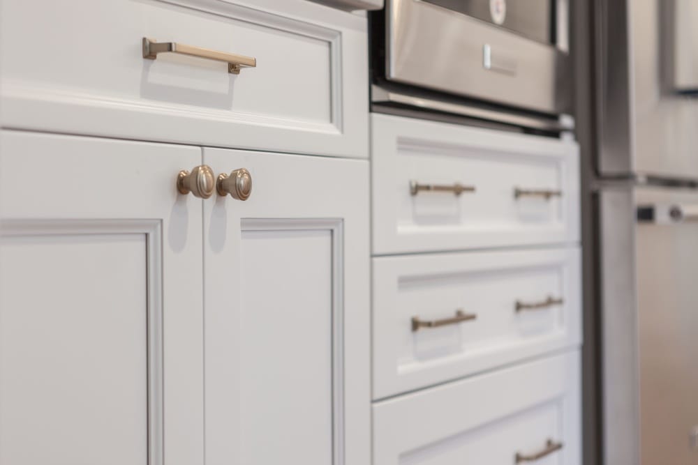 кухонные шкафы с длинными ручками и ручками-кнопками им матового золота