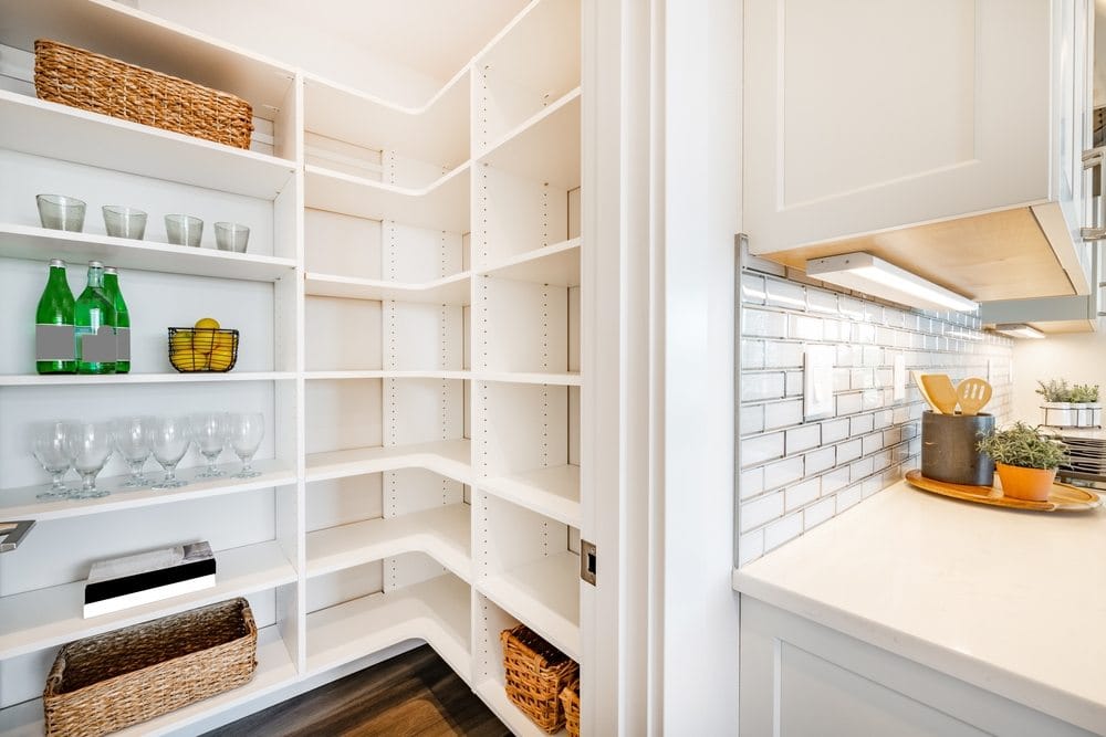 pantry and mudroom with white walls shelving hardwood floor
