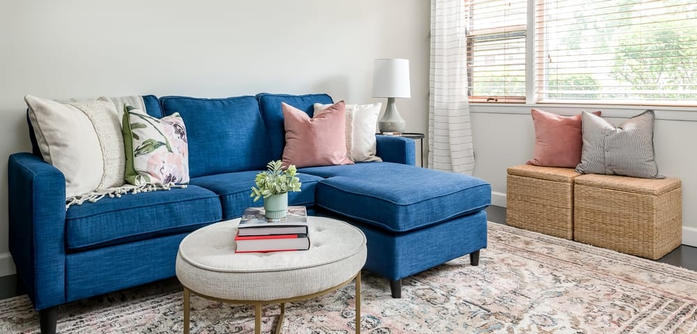 гостиная с голубым диваном и книгами на кофейном столике