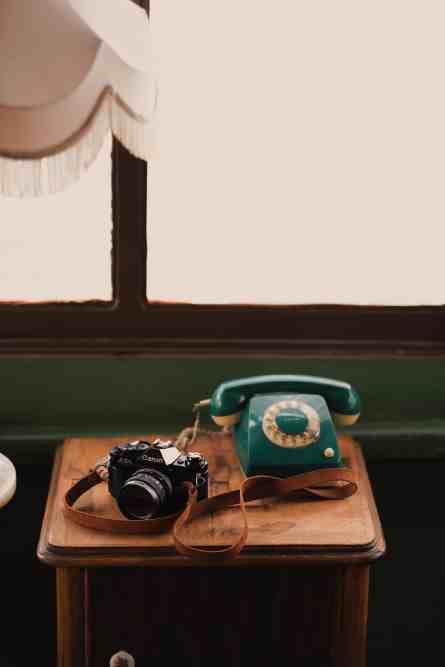 telefone e câmera de foto antiga decorando o espaço