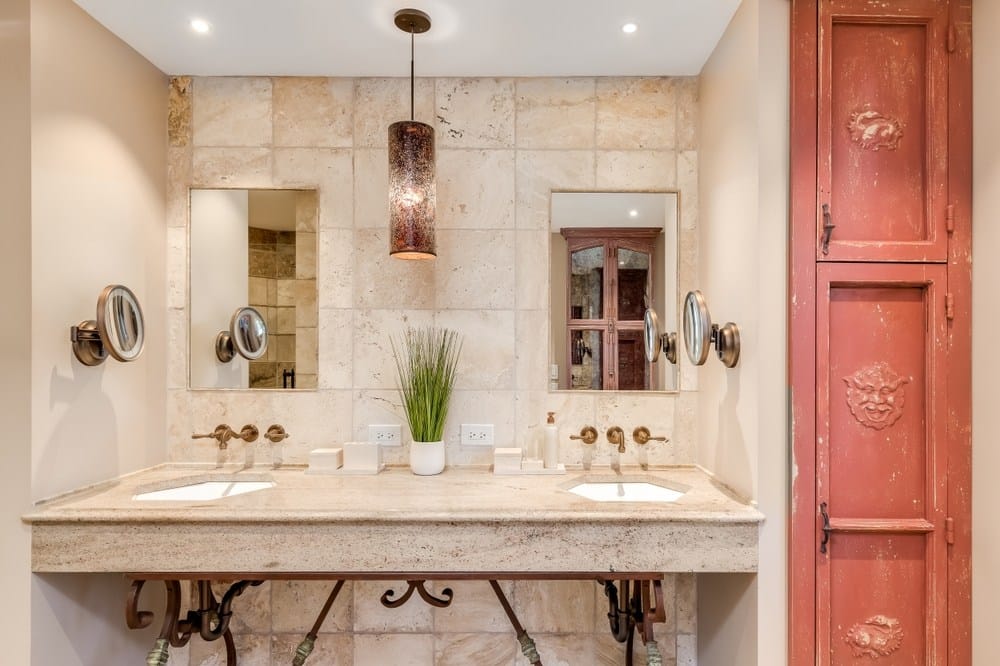 Un bagno in stile spagnolo con pareti di piastrelle in pietra marrone
