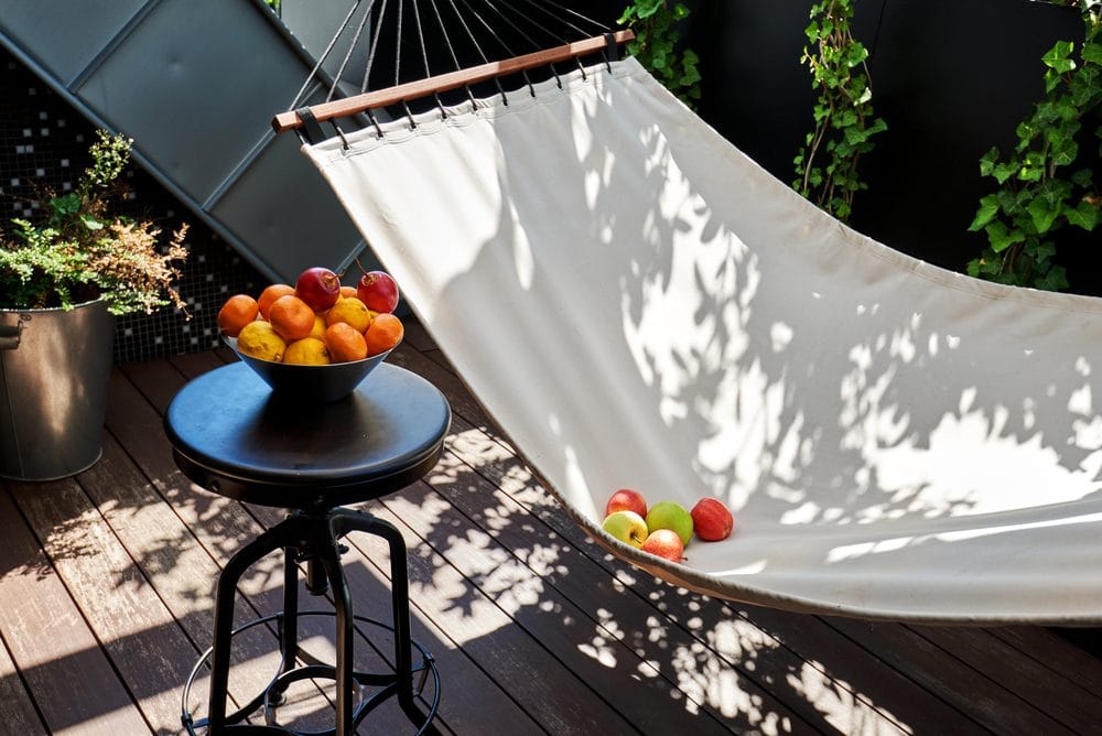 Small home patio with hammock and fruit on the table.