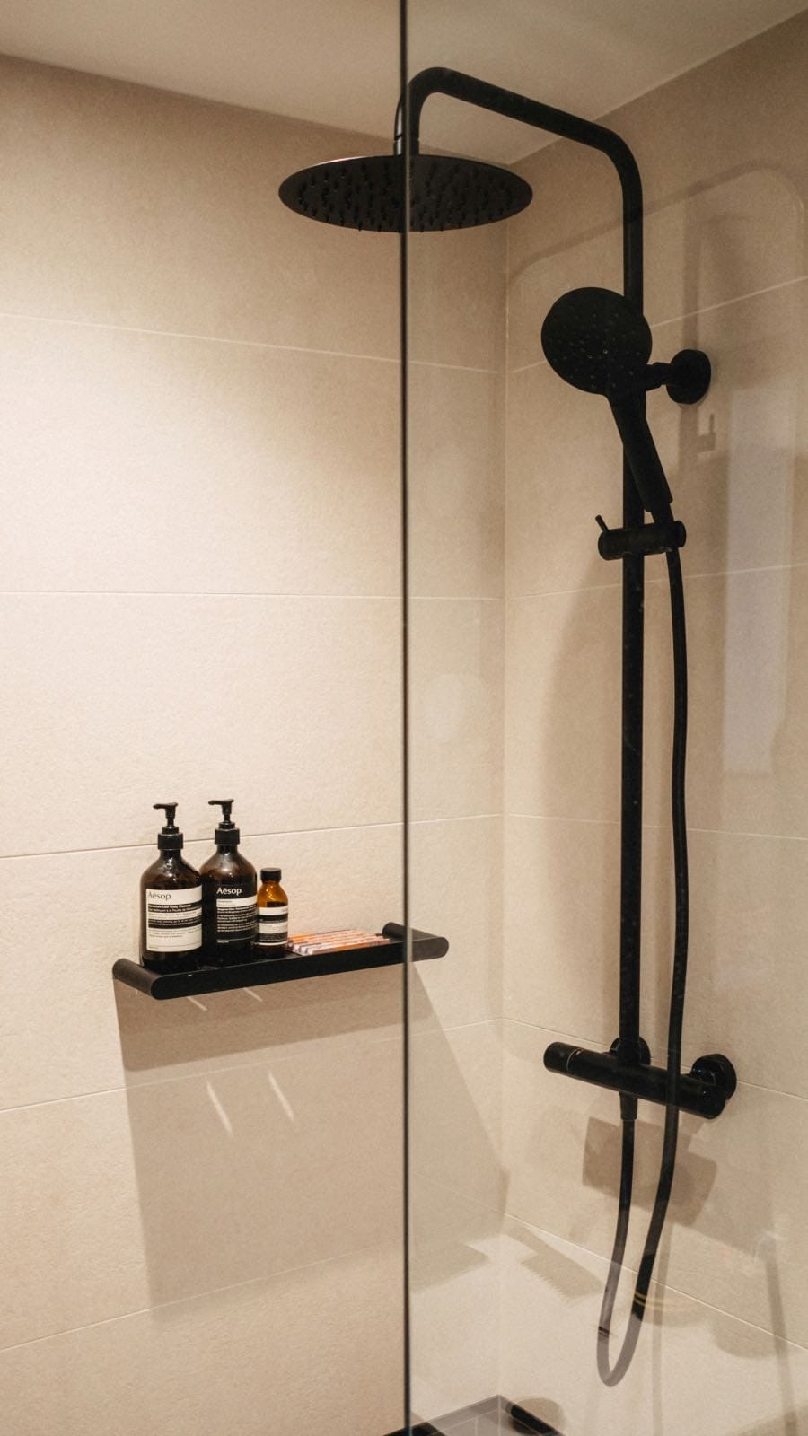 baño moderno industrial reformado con ducha negra y mampara minimalista