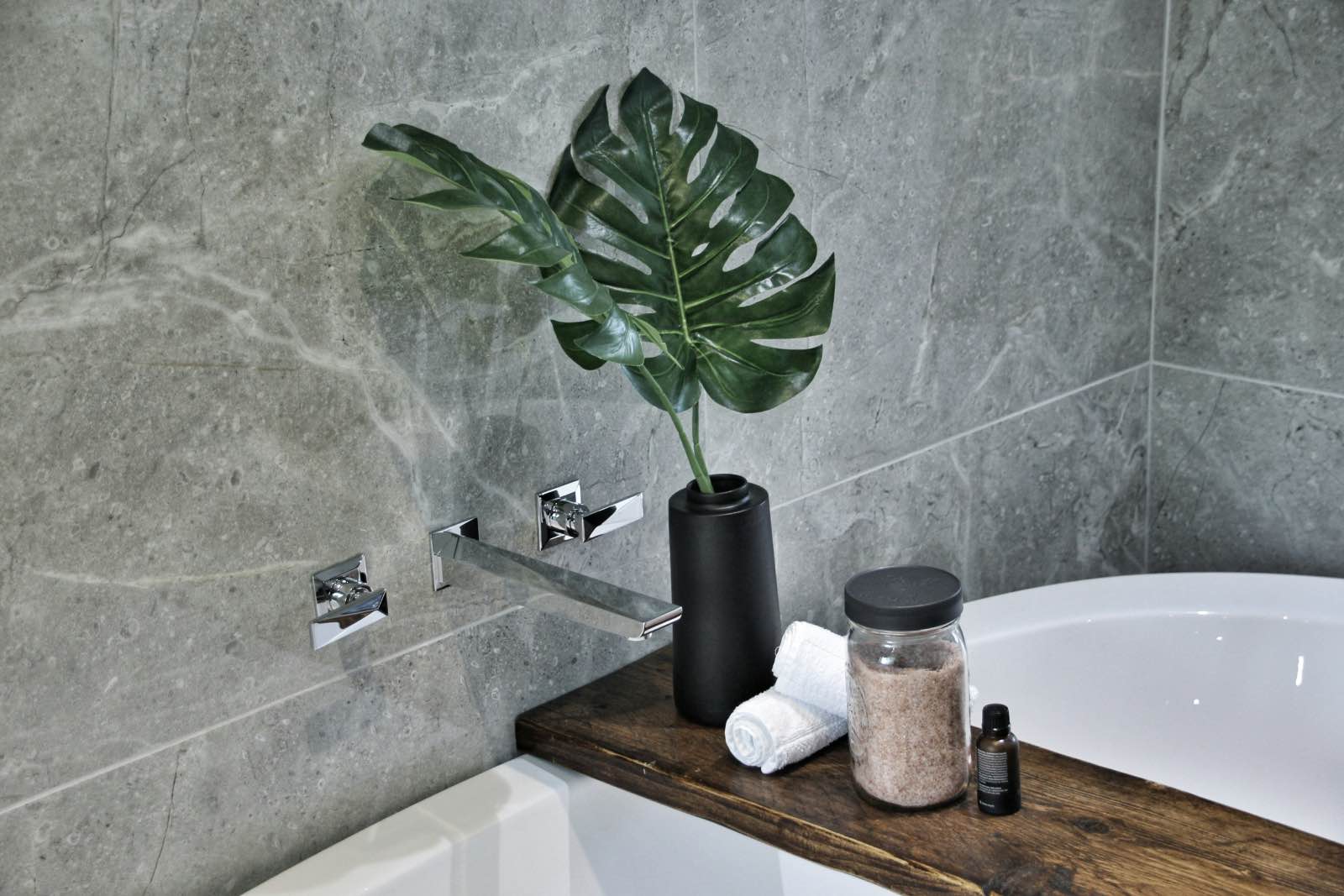 reforma de baño con paredes de granito verde, bañera con planta y grifo cromado
