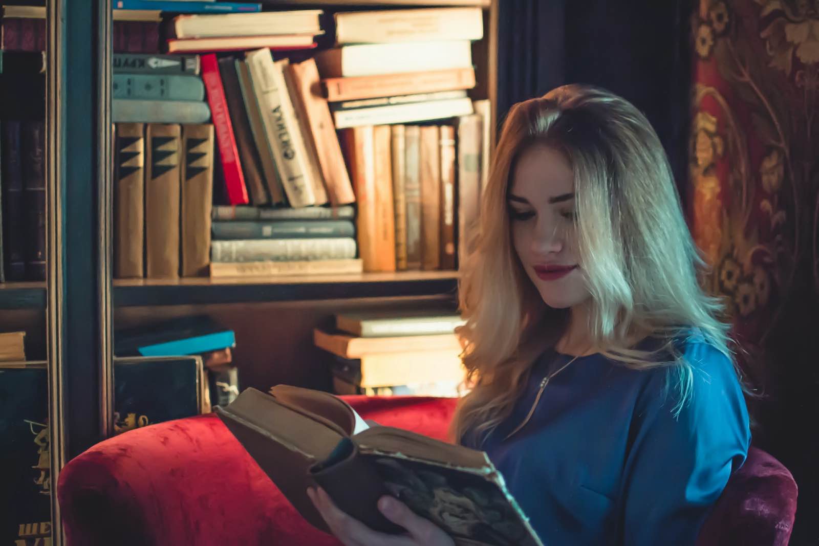mujer leyendo con libros en rincón de lectura en casa almacenaje de libros