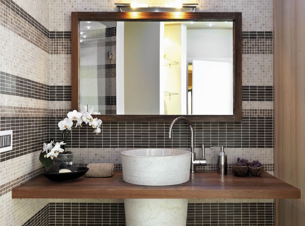 Kamienne umywalka w nowoczesnej łazience z wazonem białej orchidei