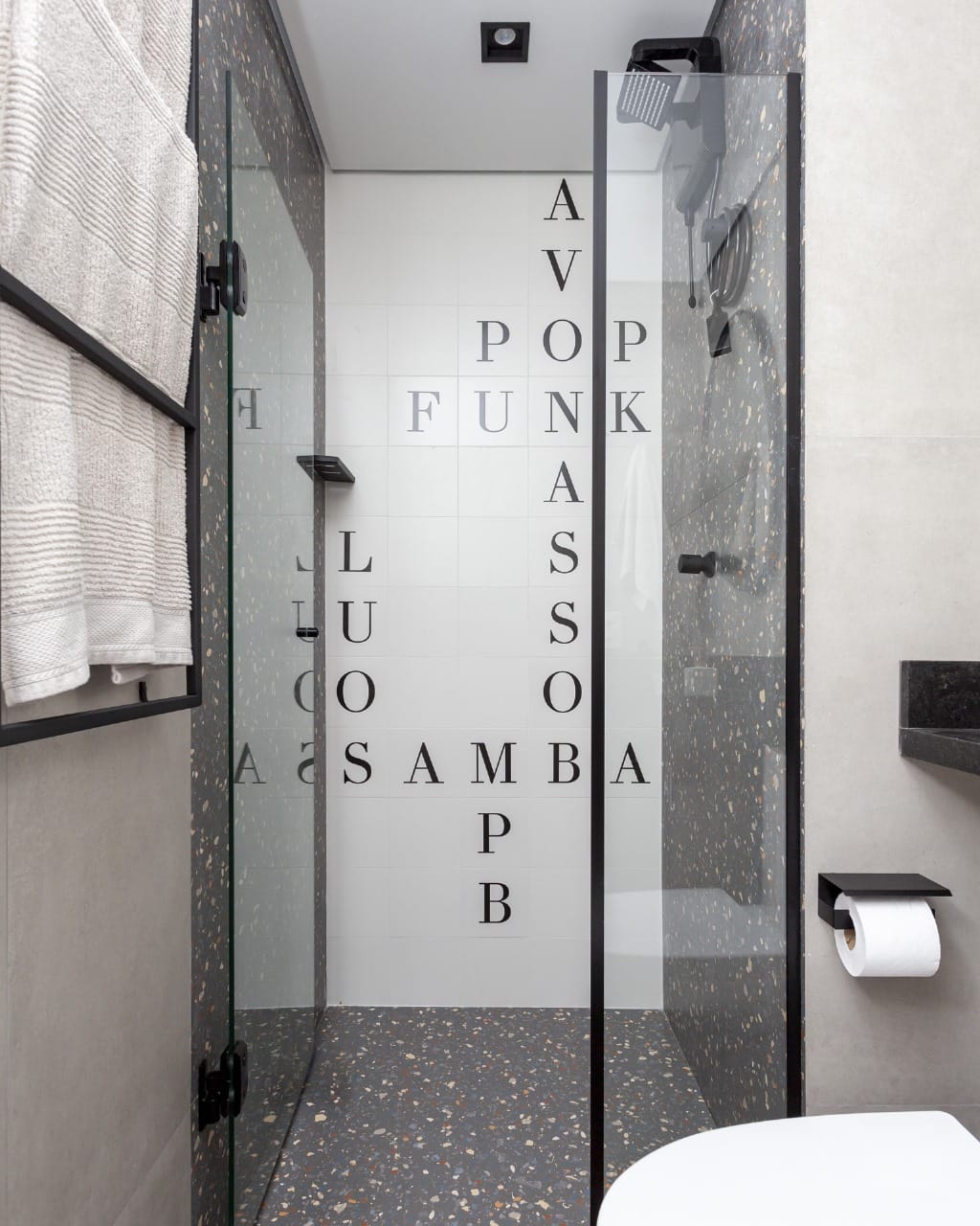 Banheiro com azulejo de letras formando estilos musicais