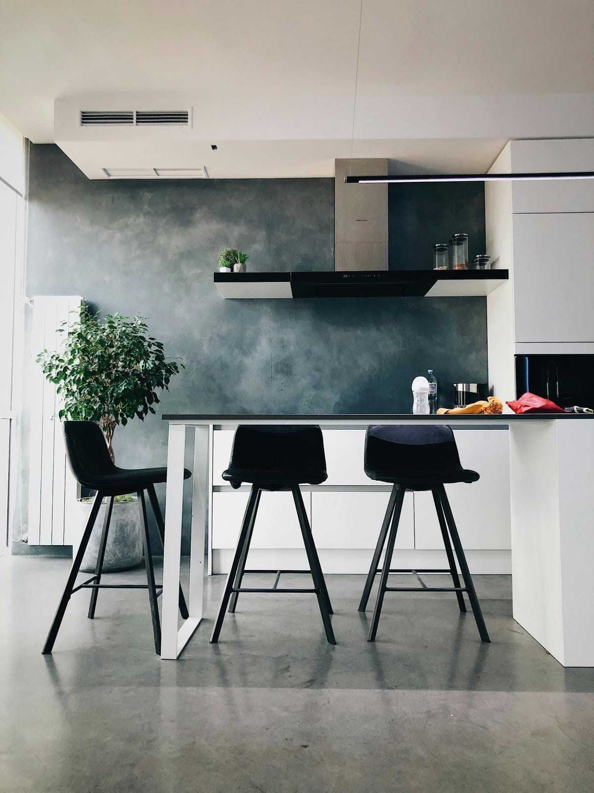 modern white kitchen with concrete backsplash and flooring