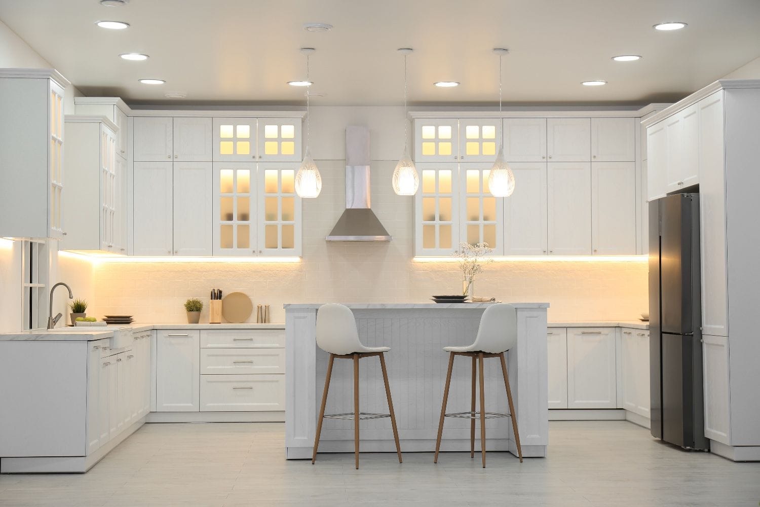 schöne moderne weiße Küche mit Pendelleuchtung