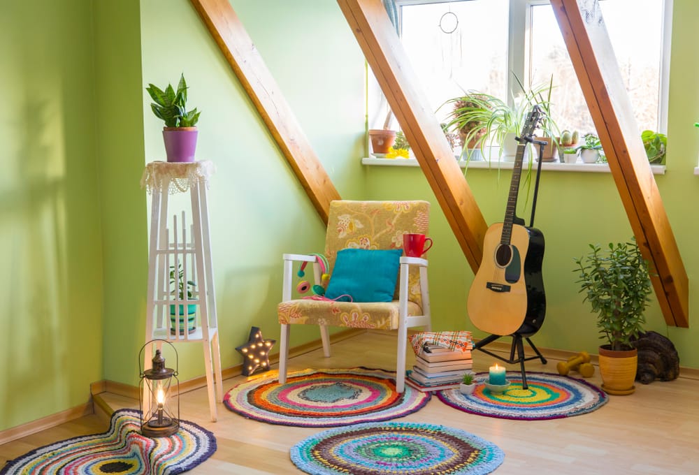 intérieur maximaliste avec des murs verts, des poutres, des plantes et une guitare