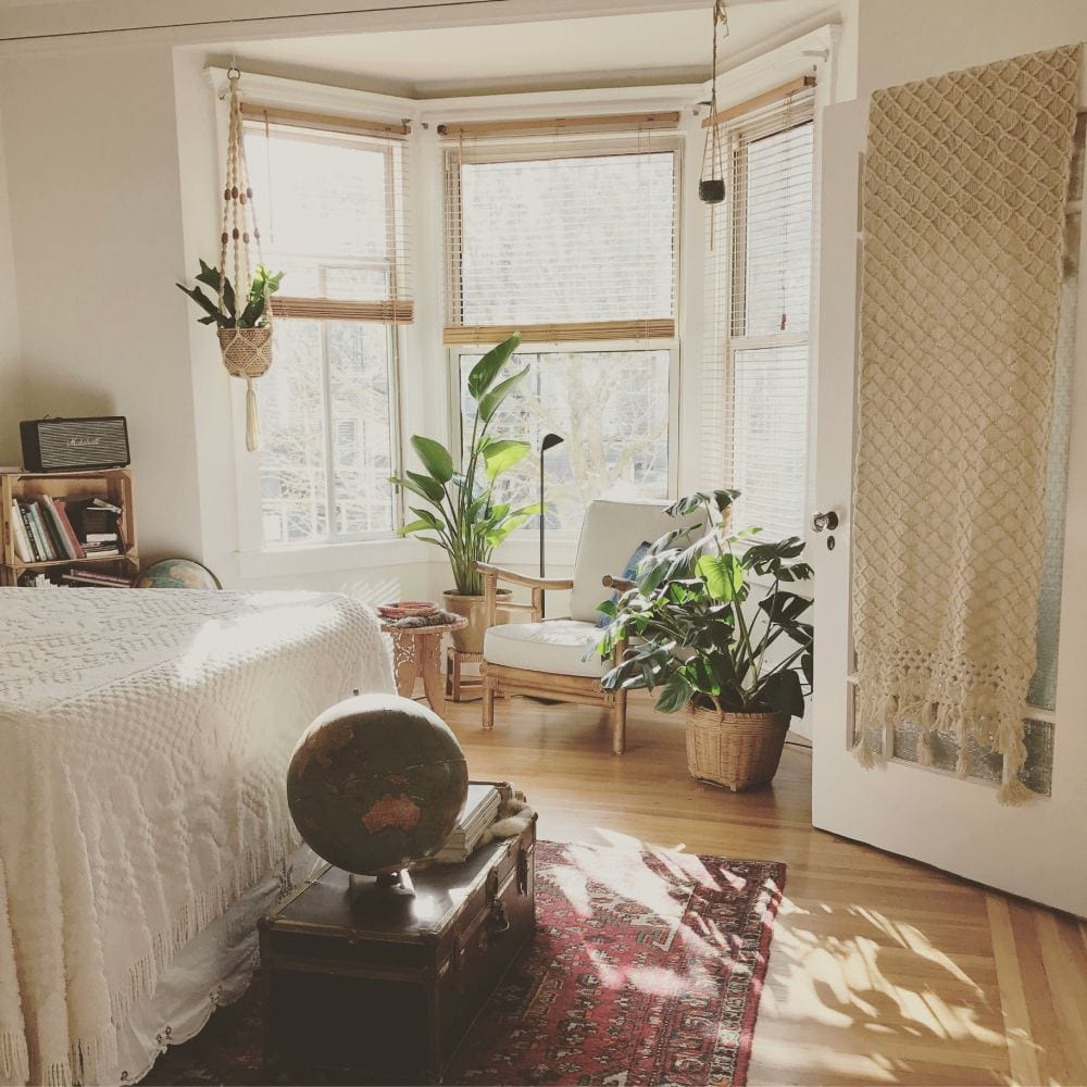 boho bedroom with potted plants by the window