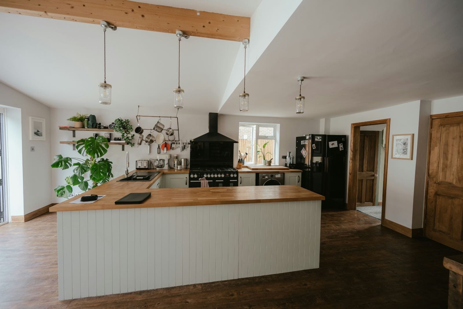 cocina blanca rústica con encimera de madera y plantas