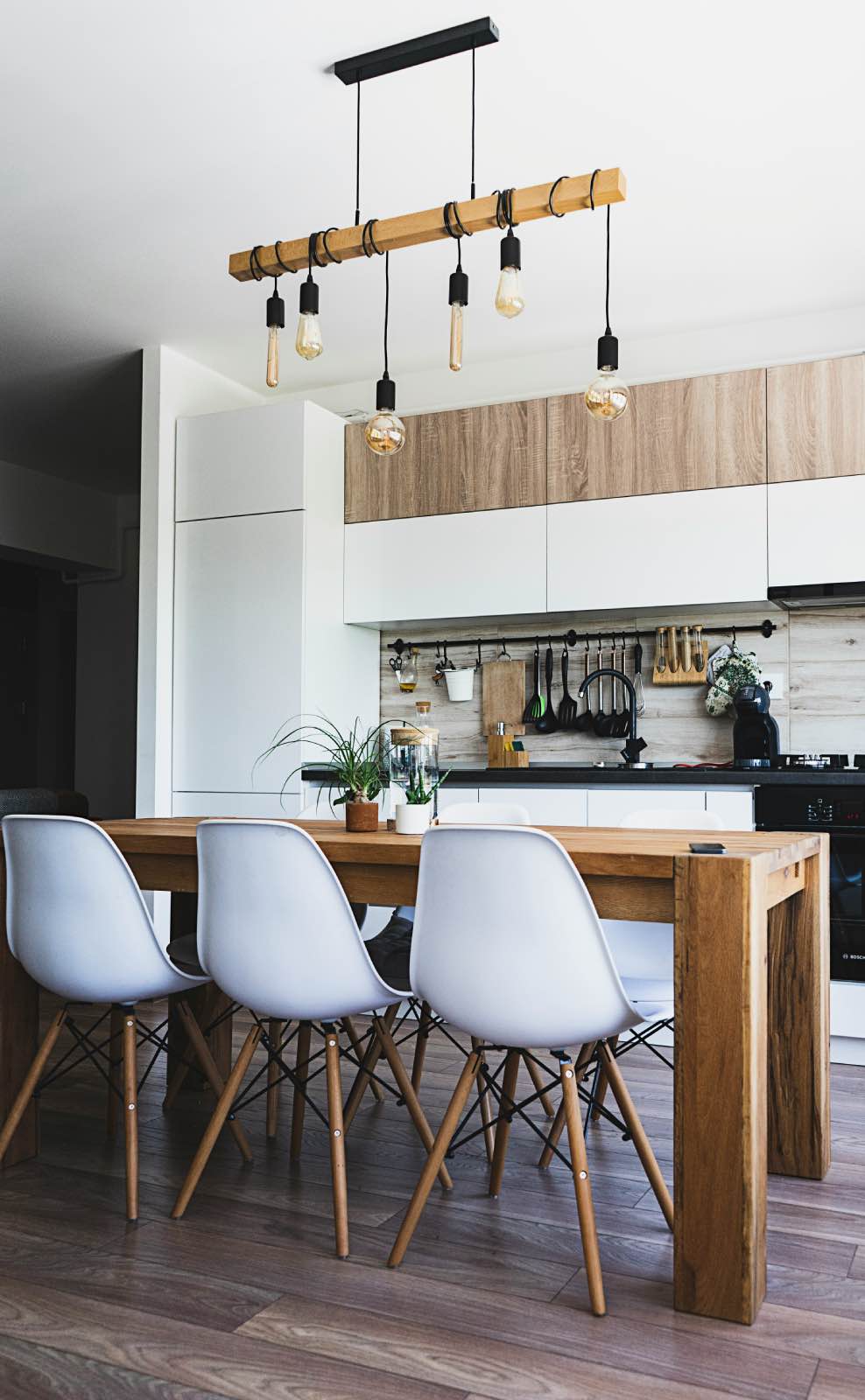 cocina blanca pequeña con mesa de madera y sillas