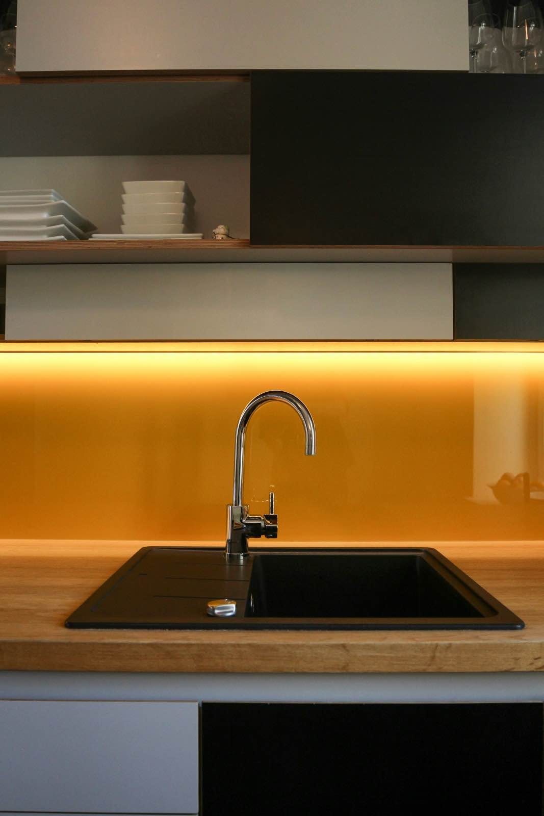 cocina de diseño moderna con fregadero negro y salpicado amarillo