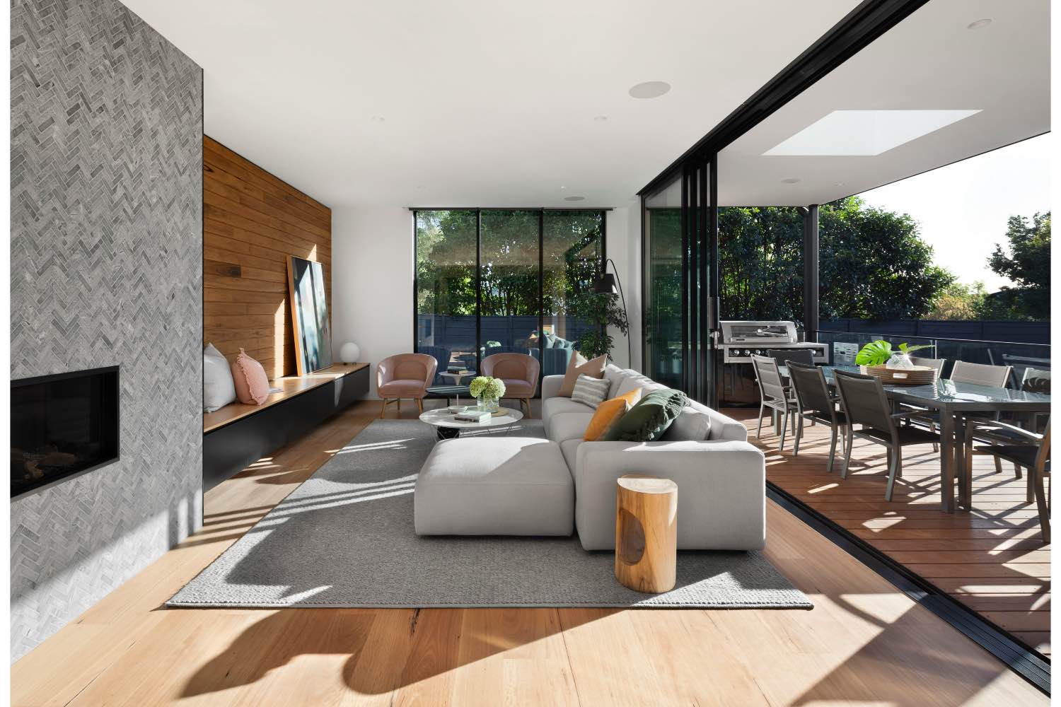 diseño de sala de estar moderna con sofá gris, chimenea y patio con comedor