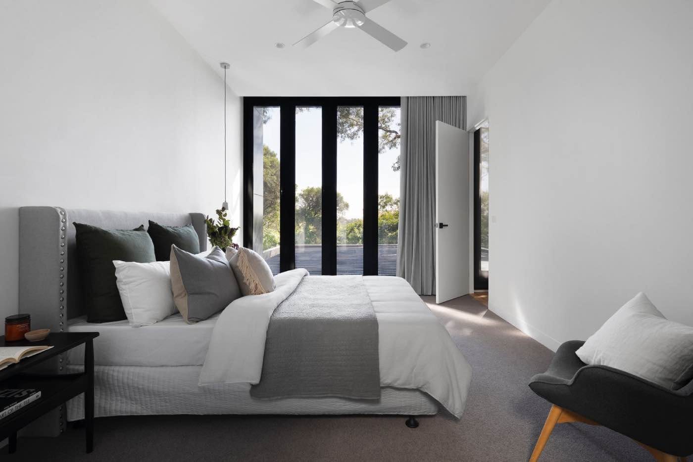 dormitorio de decoración contemporánea, cama gris, ventanas y cortinas 