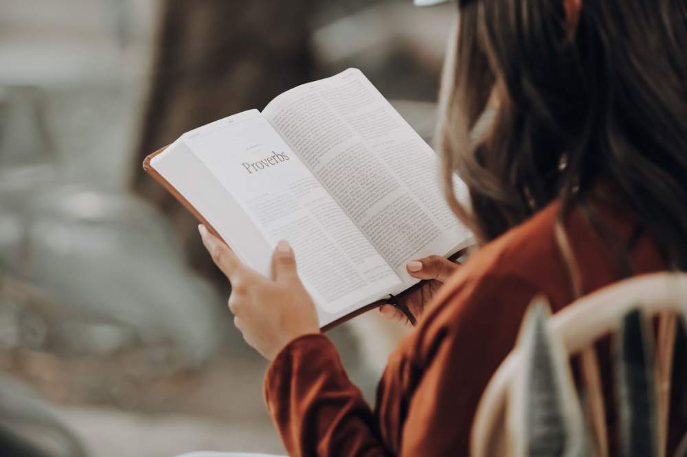 menina lendo livro em casa no cantinho de leitura