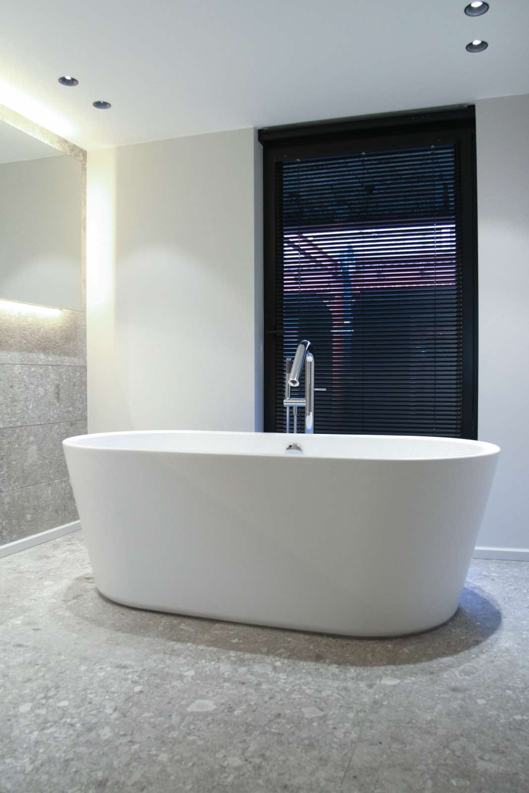 modern bathtub in white renovated bathroom