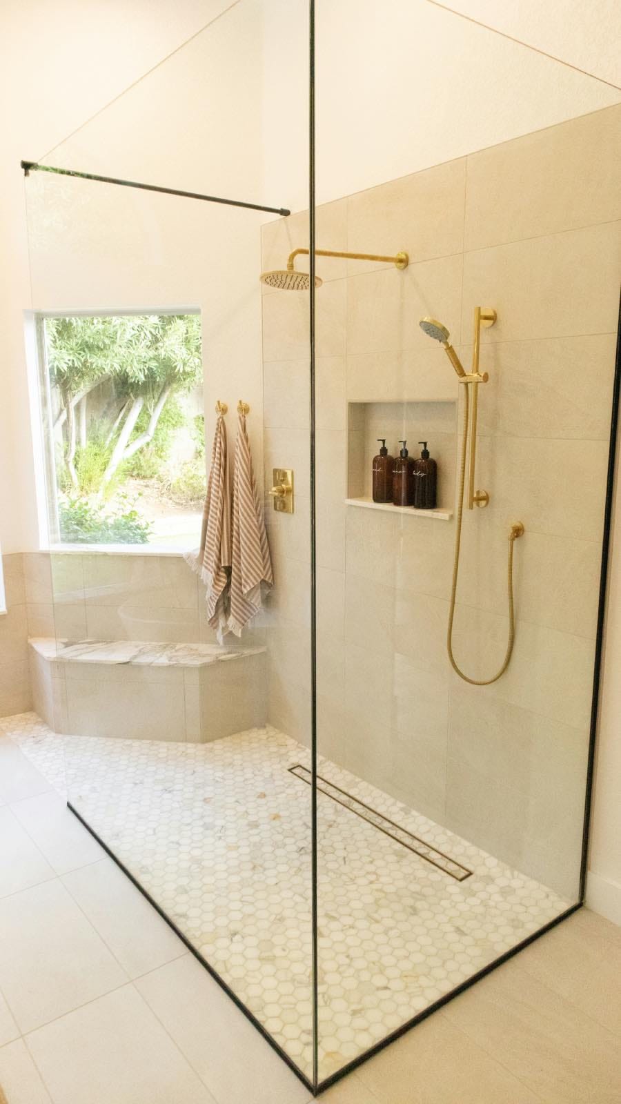 modern glass shower in white renovated bathroom with big window