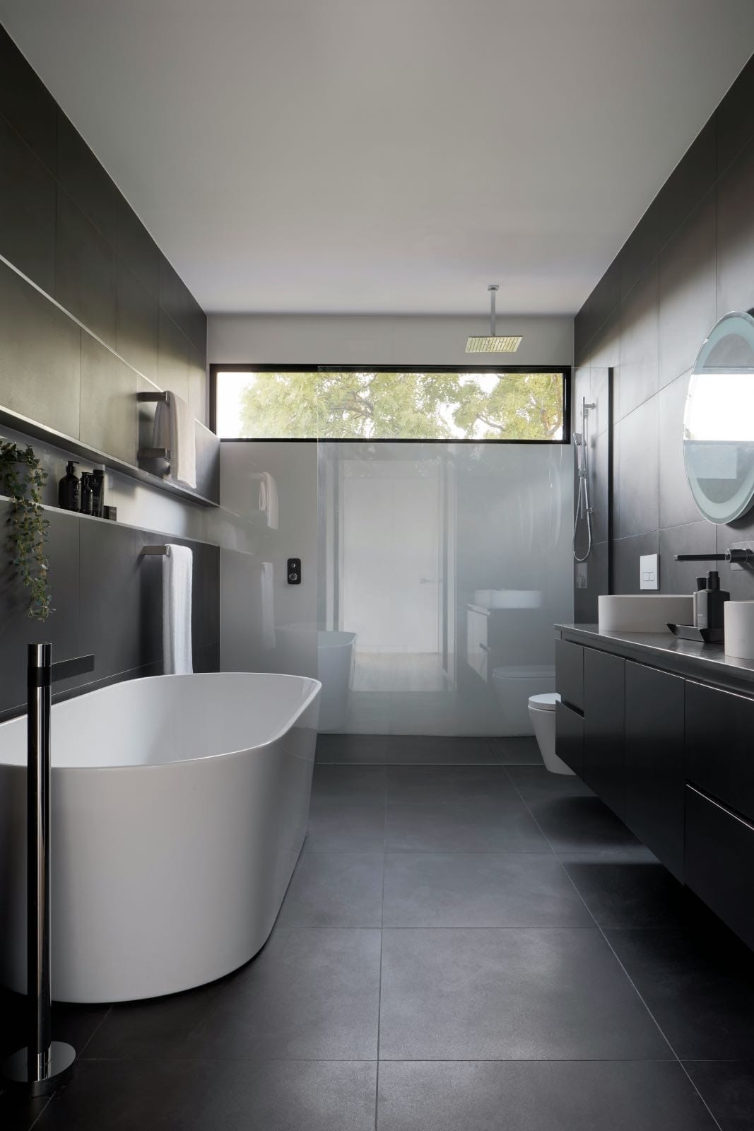 modern dark bathroom renovated with free standing tub and double sinks