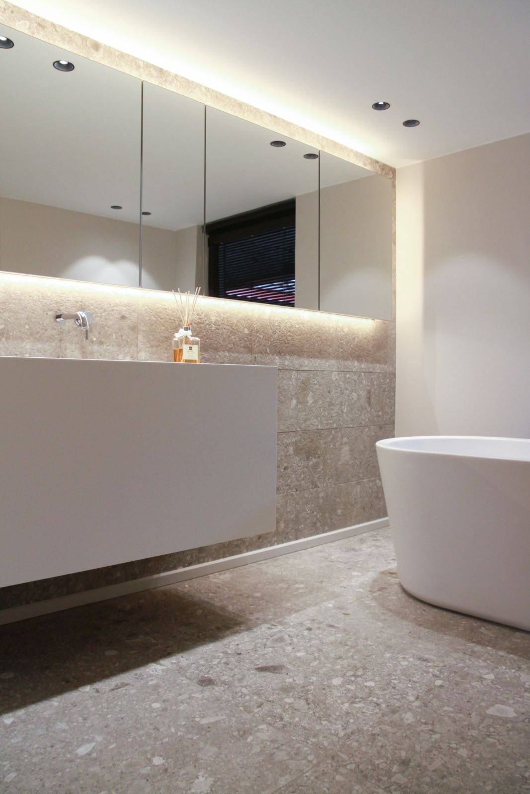 modern renovated bathroom with white fixtures and grey surfaces