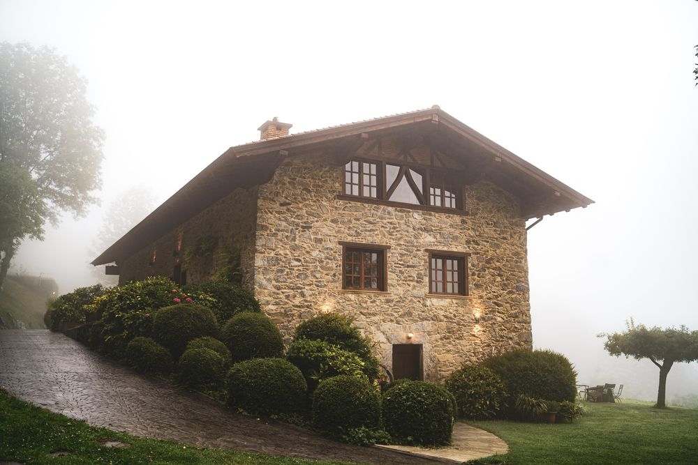 casa rústica com fachada de pedra e janelas de vidro e madeira