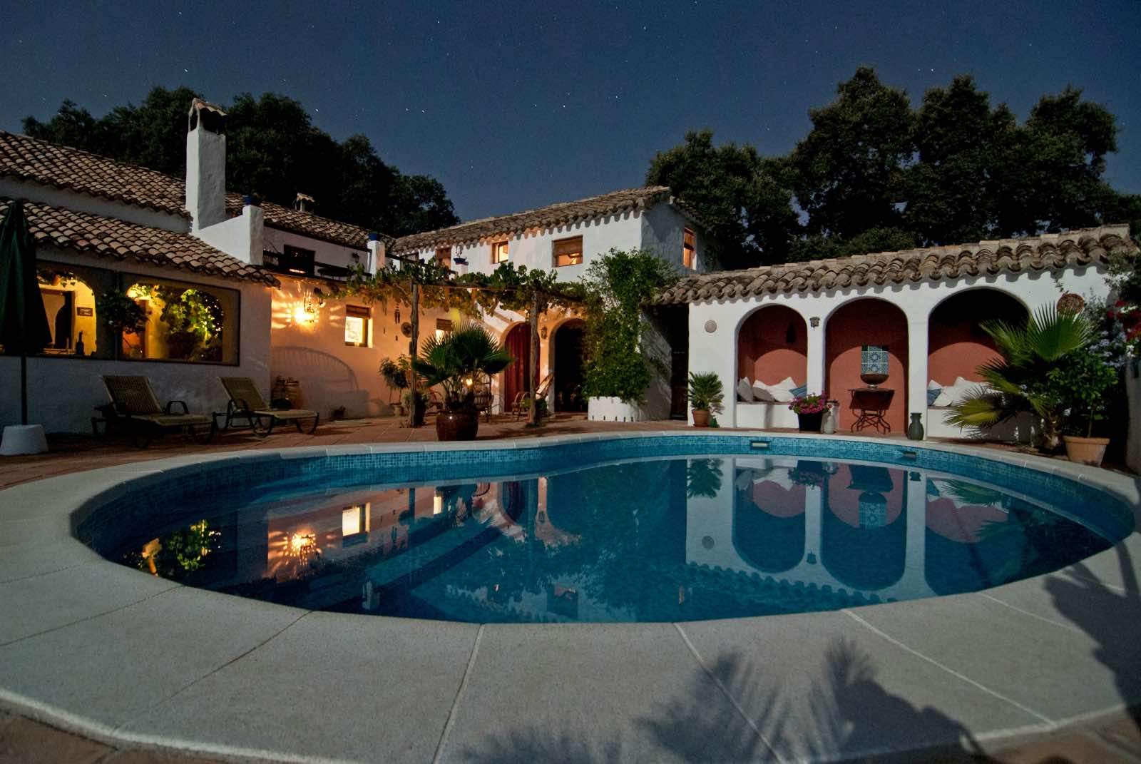 casa de estilo mediterráneo blanca con piscina y plantas