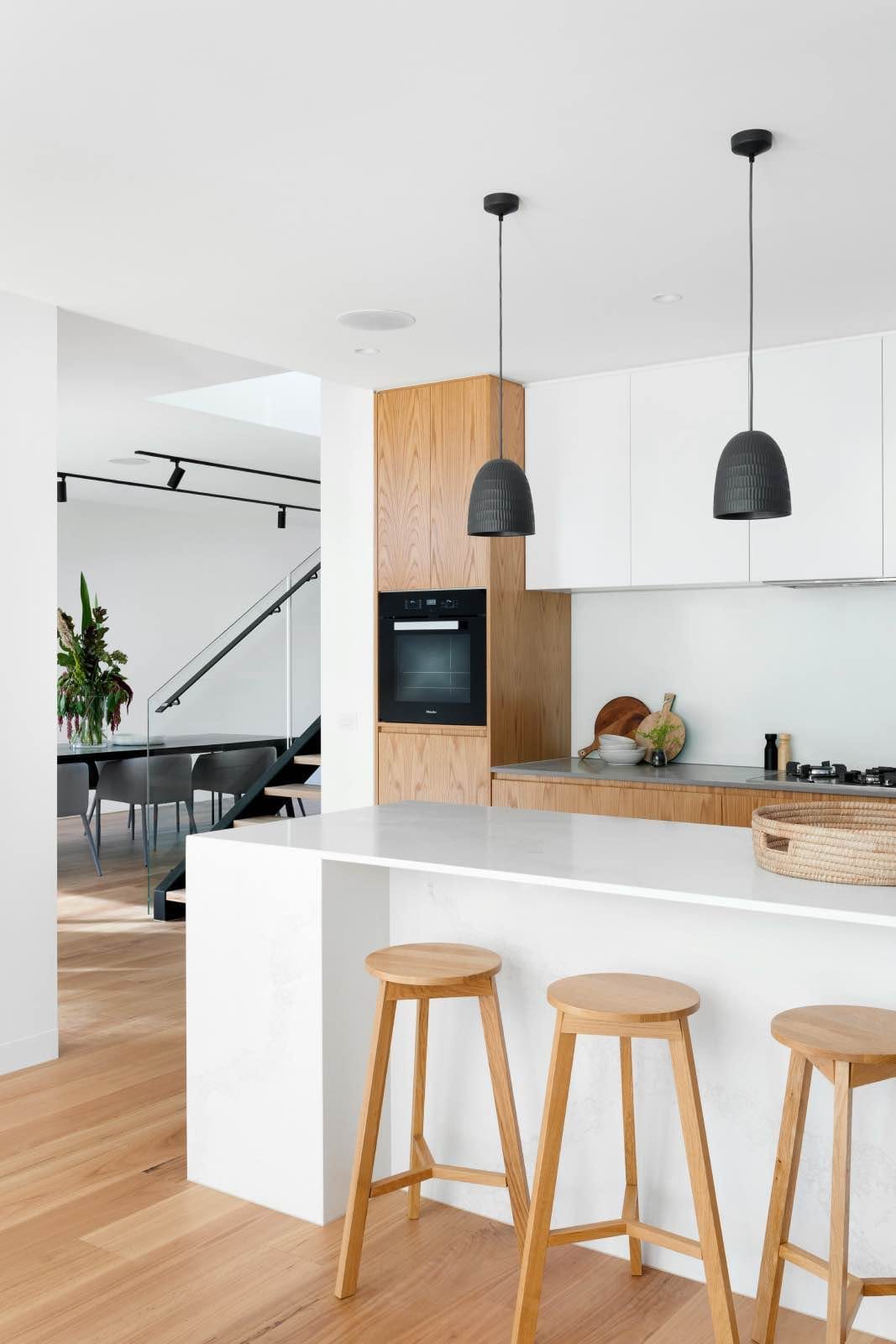 modern white kitchen with kitchen island and wooden stools
