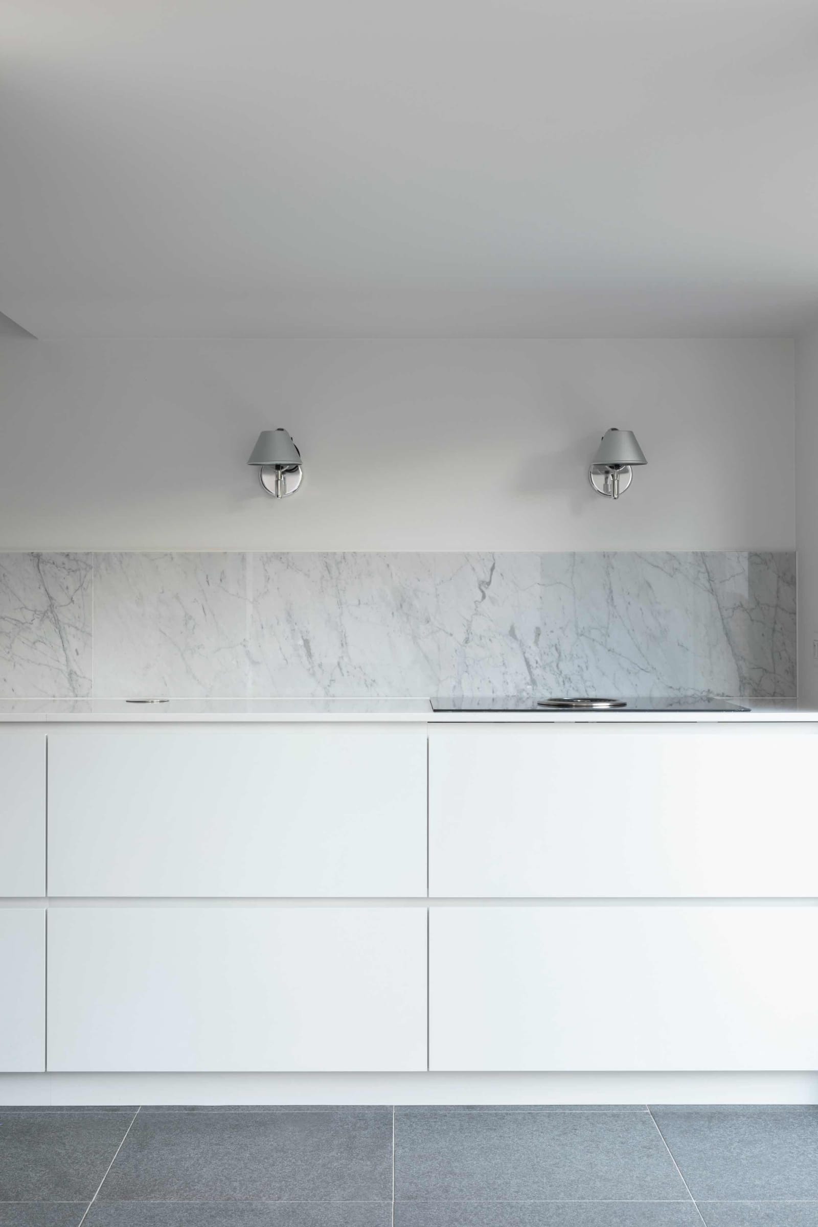 modern white kitchen with marble backsplash and countertop