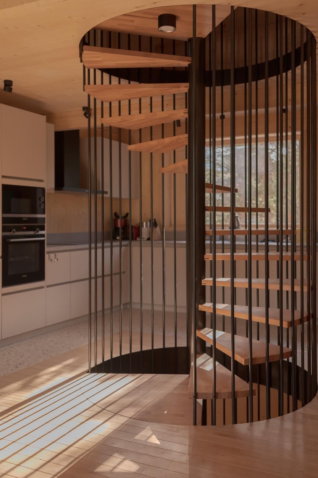 escalera de caracol de madera y metal con cocina moderna