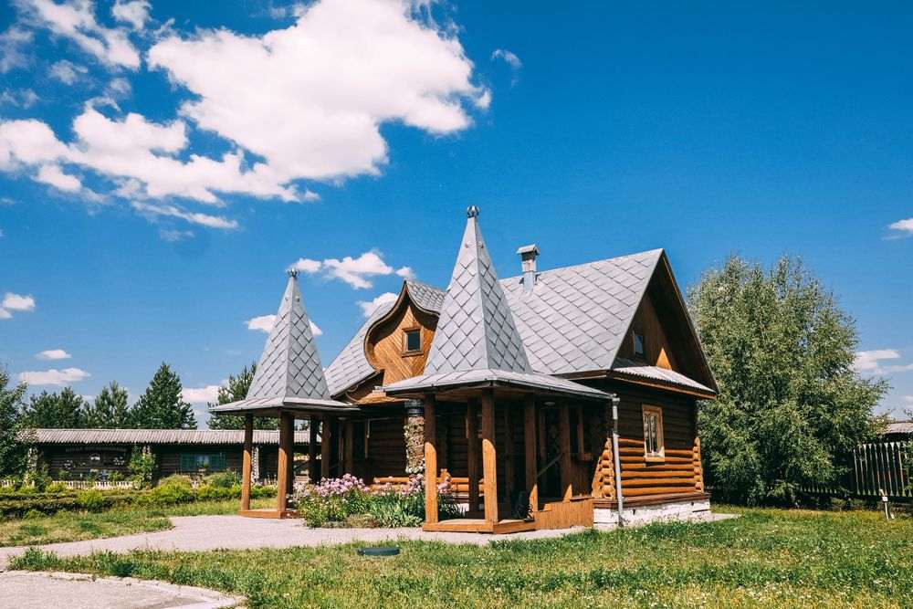 Uma charmosa casa simples feita inteiramente de madeira com gramado em sua frente