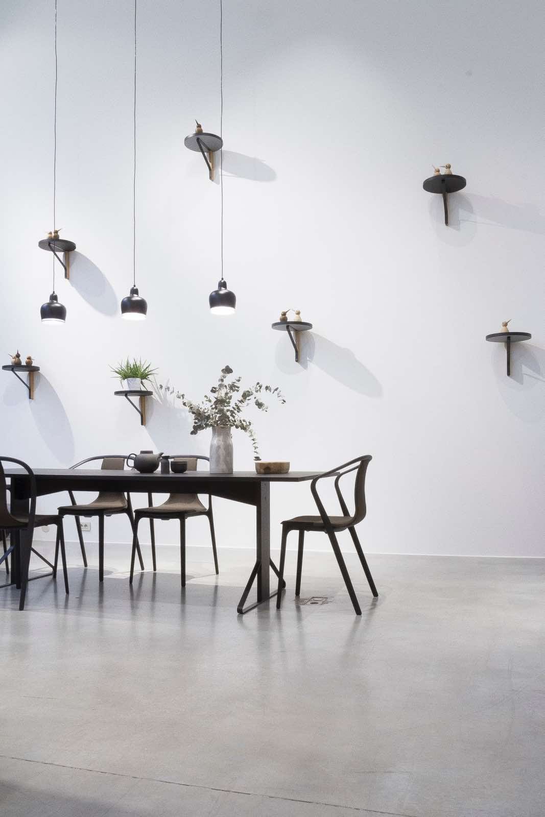 comedor minimalista con muebles modernos negros y suelo de hormigón