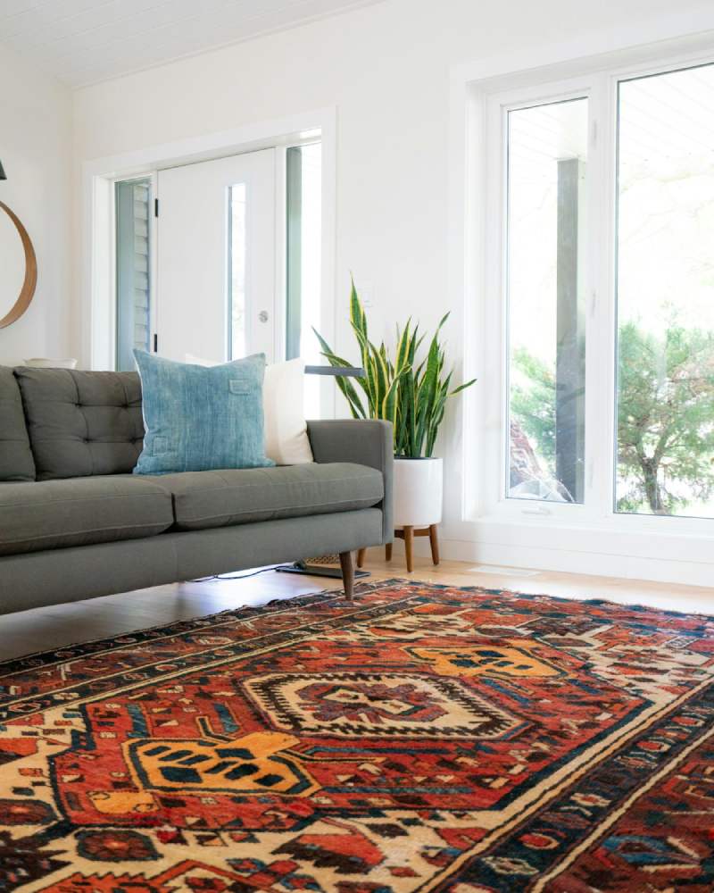 sala de estar decorada com tapete colorido e sofá cinza