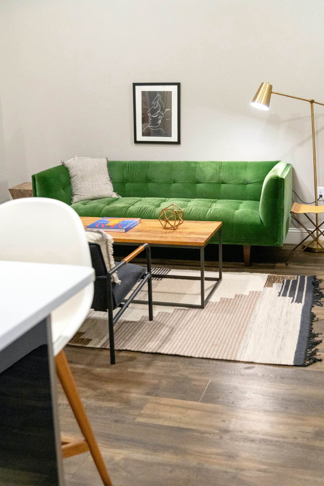 sala de estar com sofá verde, mesa de centro retangular e tapete