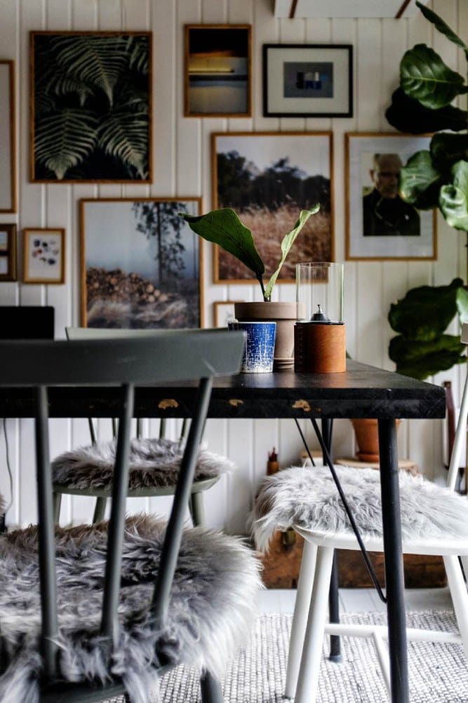 sala de estar com paredes decoradas com molduras de quadros e cadeiras com almofadas felpudas