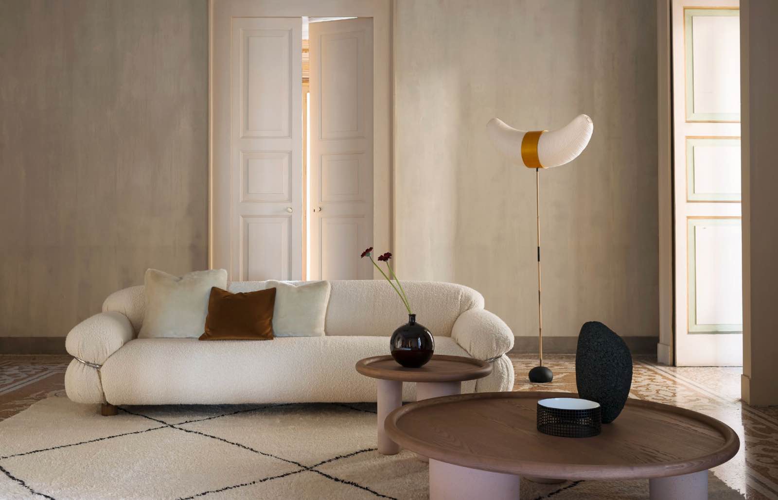 decoración años setenta con sofá curvo blanco y muebles de diseño, tacchini