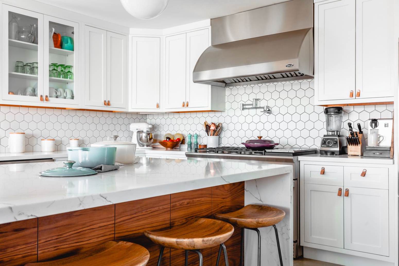 cocina blanca de diseño moderna con barra y taburetes de madera