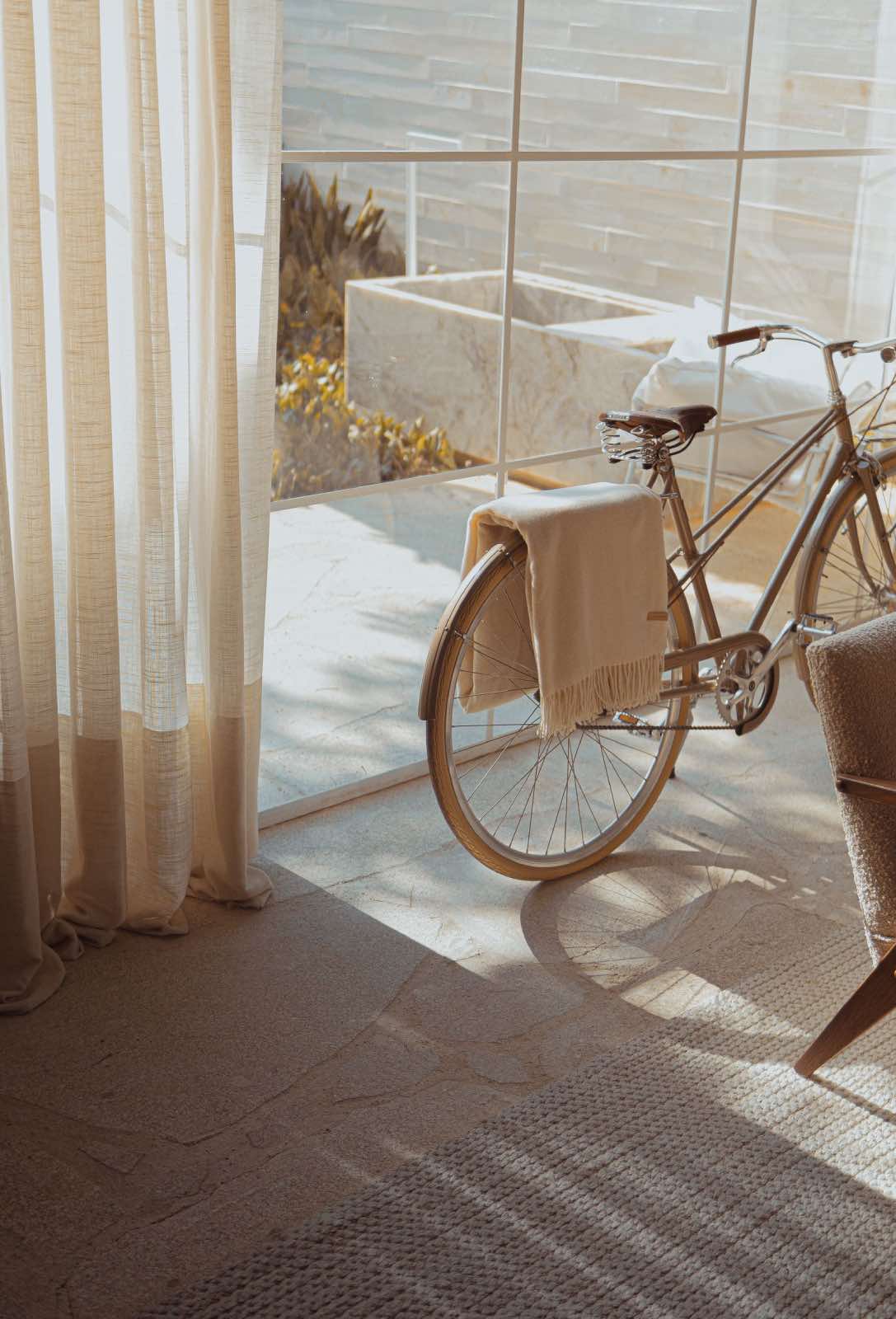 decoración sostenible, casa con cortinas de lino, alfombra sostenible, sillón y bicicleta