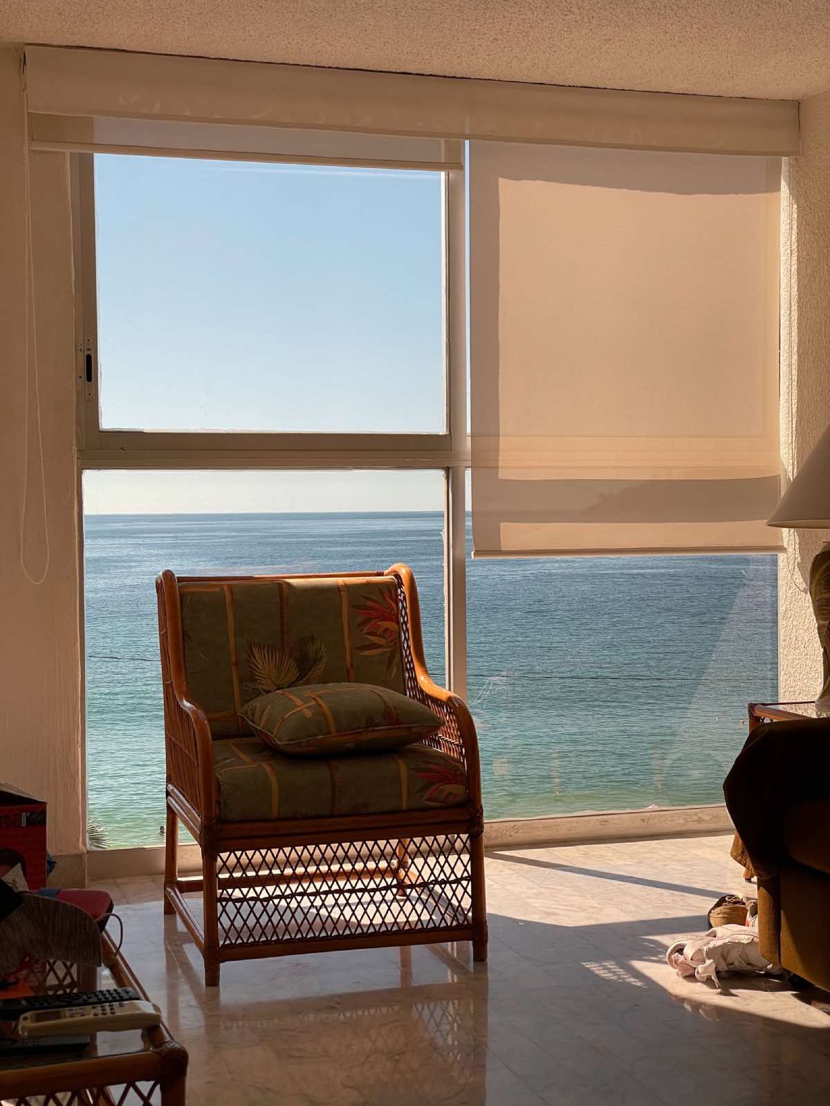 sillón clásico en sala de estar con ventanales al mar