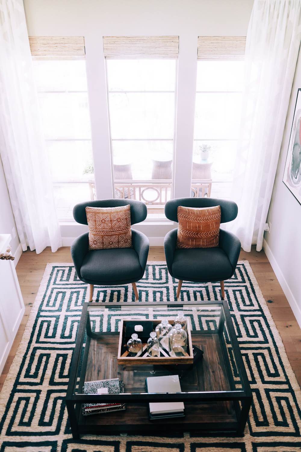 Sala de estar con tonos neutros y estampados, alfombra estampada blanca y negra