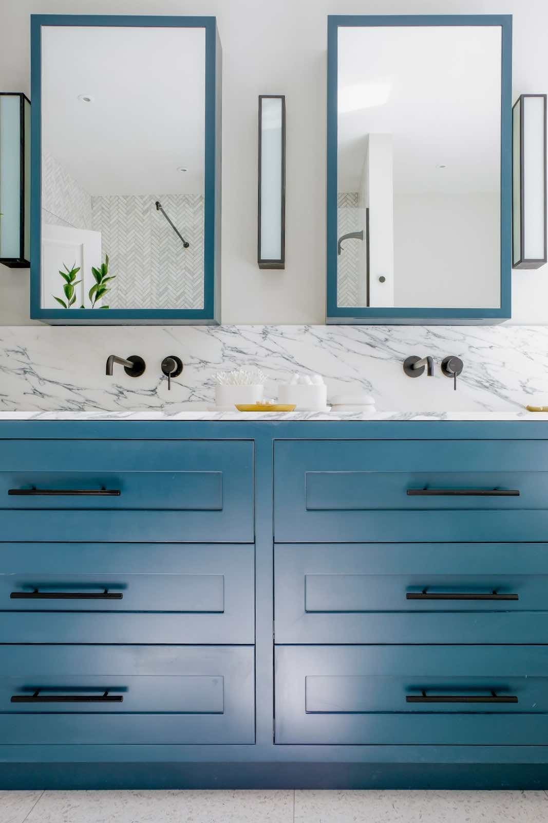 cuarto de baño moderno con mueble azul y mármol blanco