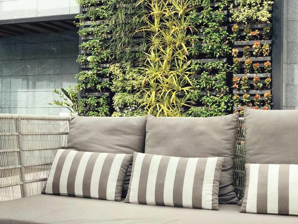 espaço ao ar livre com jardim vertical e sofá confortável