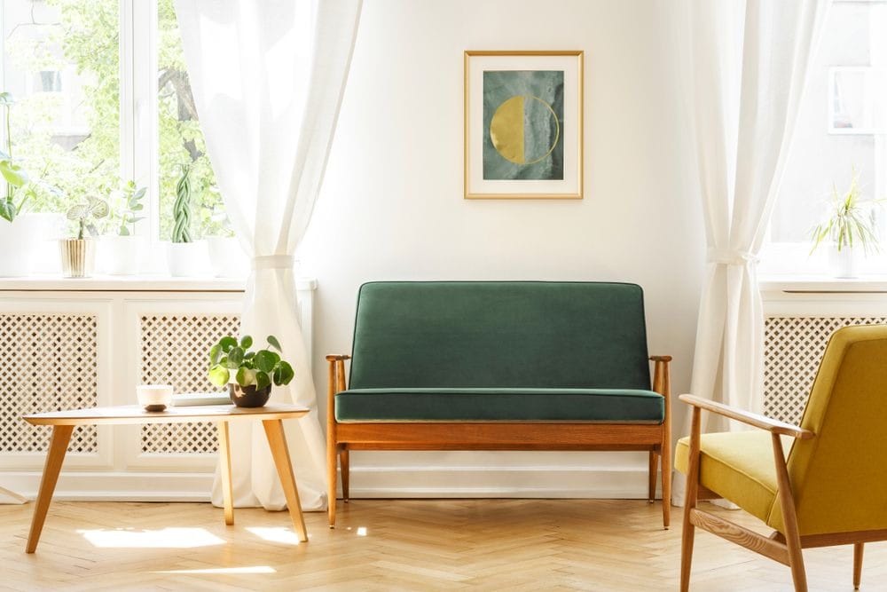 sala de estar bem iluminada estilo mid century com sofá verde e mesa de canto decorada com planta